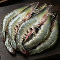 Raw giant prawns arranged on a dark board