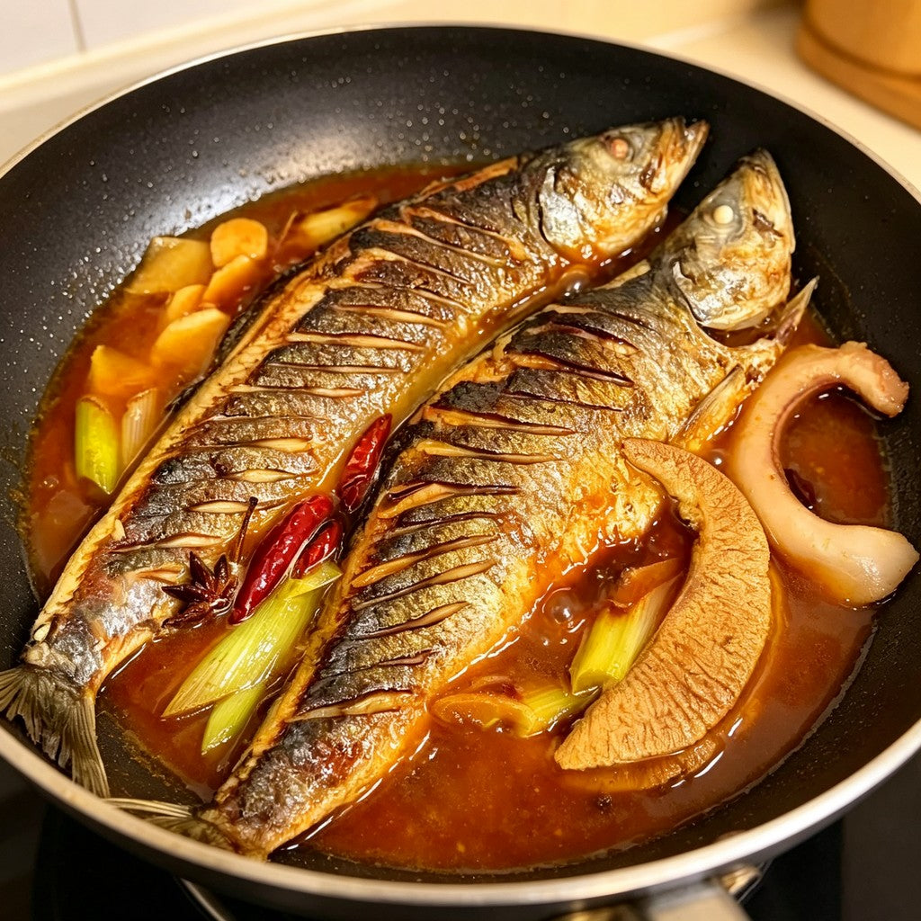 Herring simmered in a skillet with ginger and chilli